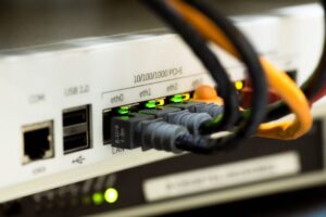 Office staff review a secured wireless router and connected devices on a computer network diagram. KEYWORDS: ["workplace Wi-Fi security", "office network router", "business wireless network"]